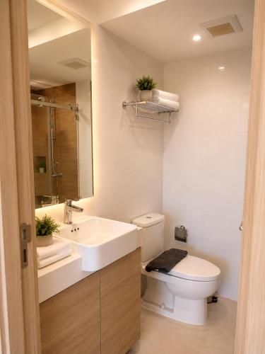 a bathroom with a white toilet and a sink at Modern Condo Infinity Pool Gym Near Beach in Bang Sare