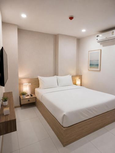 a bedroom with a large bed and a television at Modern Condo Infinity Pool Gym Near Beach in Bang Sare
