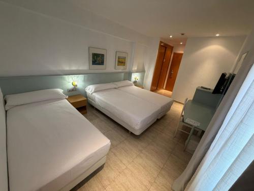 a hotel room with two beds and a desk at Fleming Center in Benidorm