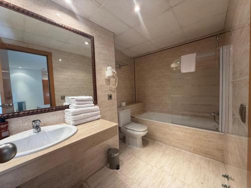 a bathroom with a sink and a toilet and a tub at Fleming Center in Benidorm