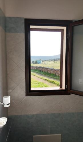 a window in a bathroom with a view of a field at Agriturismo B&B Casteldoria in Santa Maria