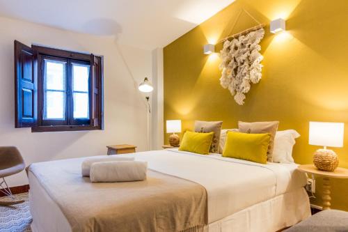 a bedroom with two beds with yellow walls at Foral Guest House in Óbidos