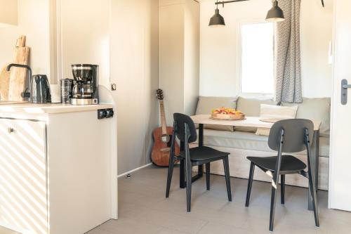 a kitchen with a table and chairs in a kitchen at Camping 3 étoiles - Piscine - ccbffbc in Saint-Denis-dʼOléron