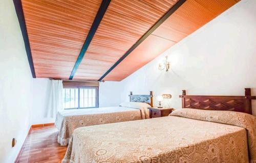 two beds in a bedroom with a wooden ceiling at Casa La Seguiriya in Las Lagunillas