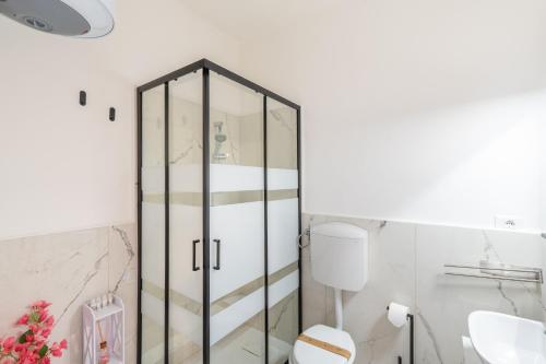 a bathroom with a glass cabinet next to a toilet at Casa Iris h Sanremo in Sanremo