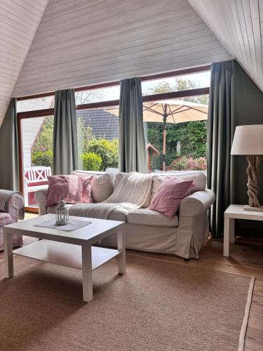 a living room with a white couch and a table at Ferienhaus Wittensee in Bünsdorf
