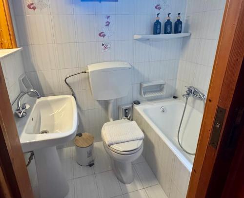 a bathroom with a toilet and a sink and a tub at Gradakia Cottages 2 in Argostoli