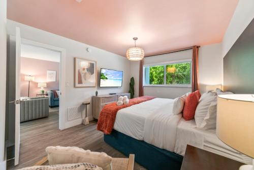 a bedroom with a large bed and a living room at King Suite, Private Beach Path, Pool & Hot Tub in Boca Raton