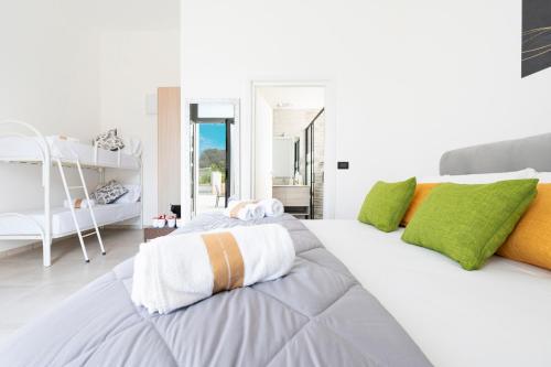 a bedroom with a large white bed with green and orange pillows at Monolocale Aurea 5 in Nardò