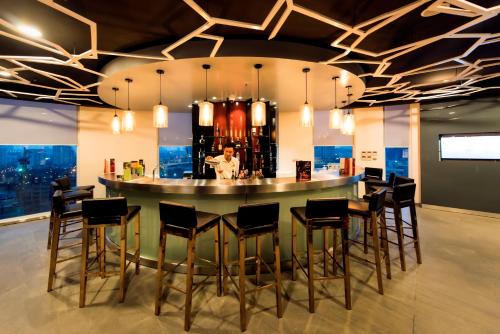 a bar in the middle of a room with stools at Novotel Suites Hanoi in Hanoi