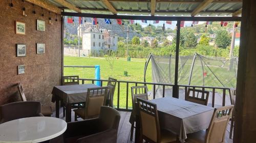 a patio with tables and chairs and a view of a field at Camping Two Rivers in Shkodër