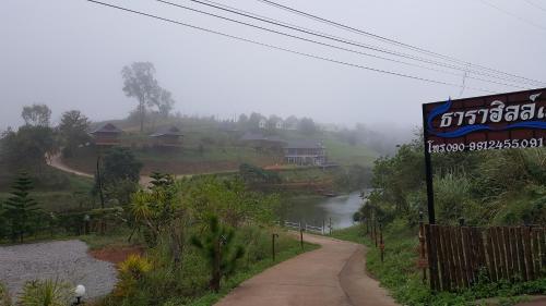 a sign on the side of a road next to a river at Tarahill Khao Kho in Khao Kho