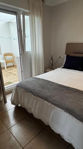 a bedroom with a bed and a door to a patio at the Beach House in A Pobra do Caramiñal