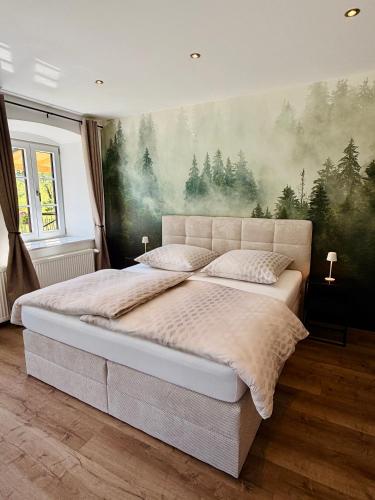 a bedroom with a large bed with a painting on the wall at Beim Mühltaler III in Schleching