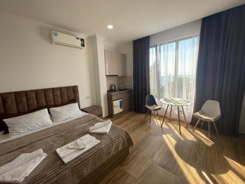 a bedroom with a bed and a table with chairs at Mzıurı House 1 in Batumi