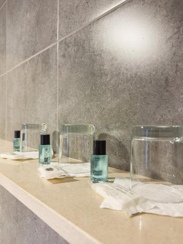 three glasses sitting on a counter in a bathroom at Hotel 13 de Outubro By Umbral in Fátima