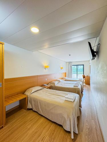 a row of beds in a room with a tv at Hotel 13 de Outubro By Umbral in Fátima