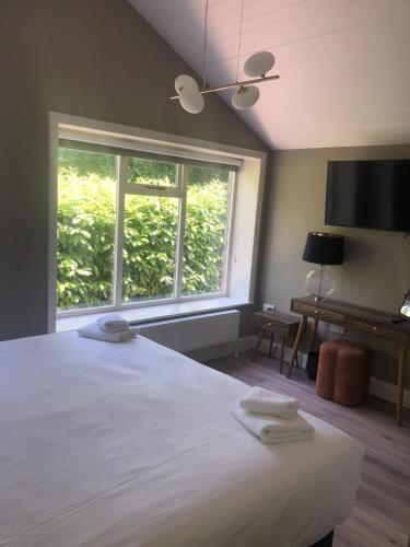 a bedroom with a large bed and a window at Wells House & Gardens Self Catering 3 Bedrooms & Sofa Bed Sleep8 in Glenranny