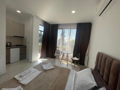 a bedroom with a large bed and a kitchen at Mzıurı House 1 in Batumi