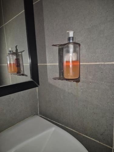 a bathroom with two glass bottles on the wall at GH Brother Eureka in Guwahati