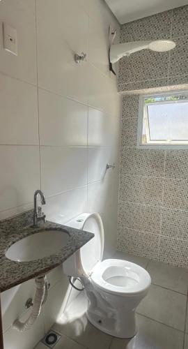 a bathroom with a toilet and a sink at Sobrado em volta do lago in Lindóia
