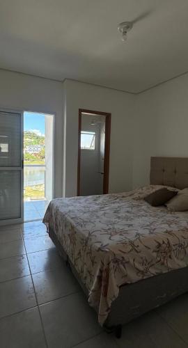 a bedroom with a bed and a large window at Sobrado em volta do lago in Lindóia