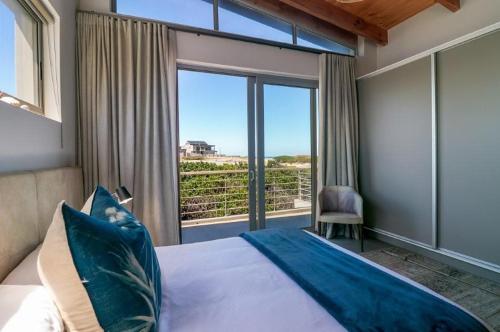 a bedroom with a bed and a large window at Jubilee in Buffelsbaai