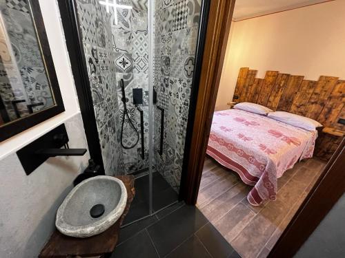 a bathroom with a shower with a bed and a sink at Costa Alta - Casa Vacanze in Arcevia