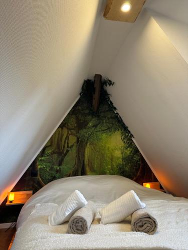 a bed with two towels on it with a painting at La Cabane in Dambach-la-Ville