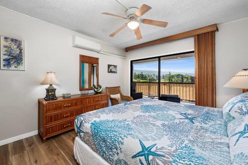 a bedroom with a bed with a ceiling fan and a window at Kona Plaza#409 in Kailua-Kona