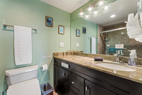 a bathroom with a sink and a toilet and a mirror at Kona Plaza#409 in Kailua-Kona
