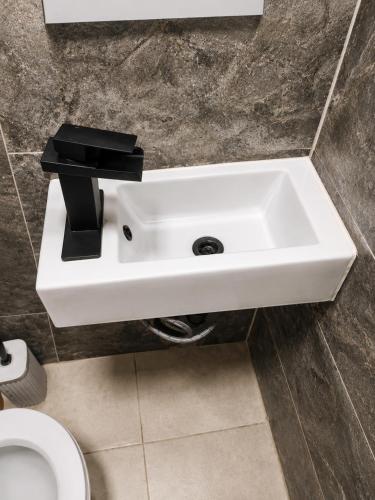 a white sink in a bathroom with a toilet at Respite room in Chambly