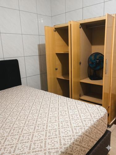 a bedroom with a bed and a cabinet with a bowl at Residencia Siqueira in Garopaba