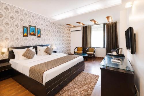 a hotel room with a bed and a television at Skylark Hotel by Gabrian Hotels in Gurgaon