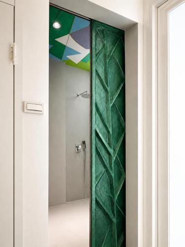 a green glass door in a bathroom with a shower at 大樹林 Mori Mori 包棟民宿 寵物友善 附車位 in Tainan