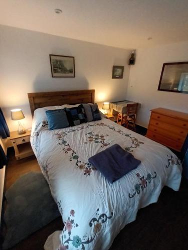 a bedroom with a large bed with blue pillows at The Captains in Bettyhill
