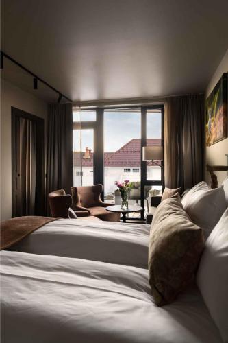 a hotel room with two beds and a large window at Dr. Holms Hotel in Geilo