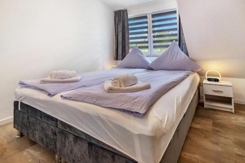 a bedroom with a large bed with towels on it at Luv Lee Duhnen 06 in Cuxhaven