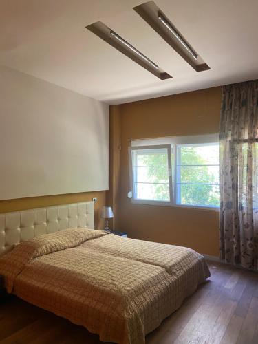 a bedroom with a large bed and a window at Bylis Rooms in Golem