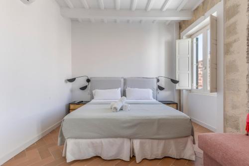 a bedroom with a white bed with a stuffed animal on it at Suite 3 in Mahón