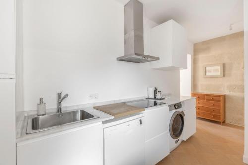 a white kitchen with a sink and a washing machine at Suite 3 in Mahón