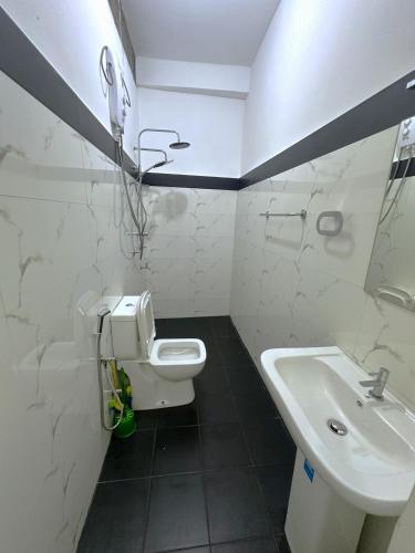 a white bathroom with a sink and a toilet at White House Galaha in Galaha Town