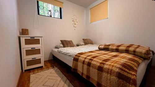 a small bedroom with a bed and a dresser at Laguna Turawa in Turawa