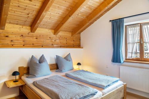 a bed in a room with a wooden ceiling at Ferienwohnung Gipfelblick in Oberau