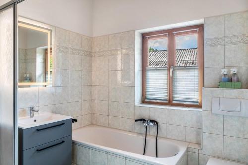 a bathroom with a tub and a sink at Ferienwohnung Gipfelblick in Oberau