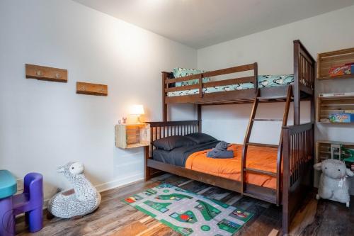 a bedroom with two bunk beds and a rug at Ours noir spa waterfront in Chertsey