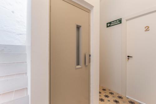 a door in a hallway with a sign on it at Suite 2 in Mahón