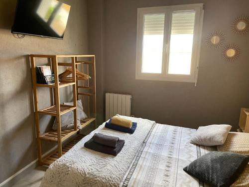 a bedroom with a bed with two towels on it at Maison avec balcon in Saint-Hilaire-Petitville
