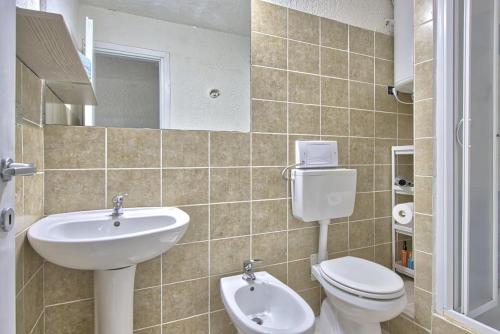 a bathroom with a sink and a toilet and a mirror at Monolocale al centro della Costa Smeralda in Cugnana Verde
