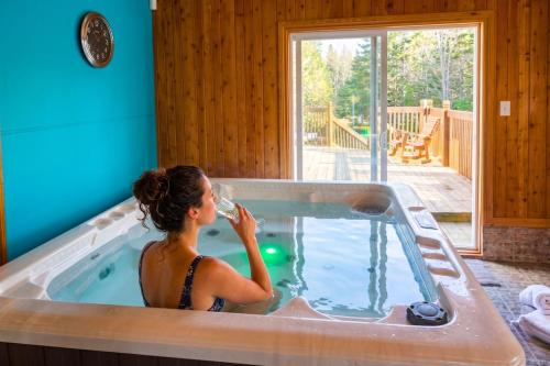 a woman in a hot tub in a house at La Tour Boisée with Private Spa & Pool, Pool Table in Sainte Béatrix